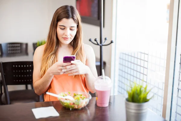 Skicka SMS till en kompis medan man äter lunch — Stockfoto