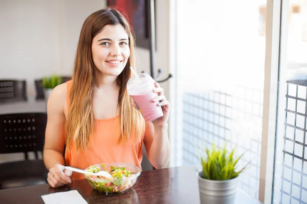 Mujer disfrutando de un batido y ensalada — Foto de Stock