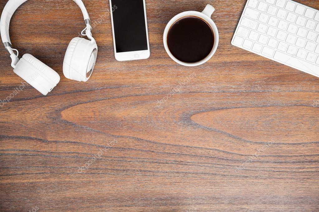 desk with a computer keyboard, a smartphone