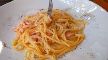 Beyaz bir tabaktan çatal rüzgar makarna.