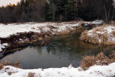Kış günü küçük, dolambaçlı bir nehir manzarası