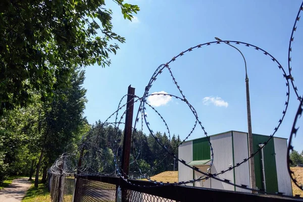 The building is located behind barbed wire, protected object