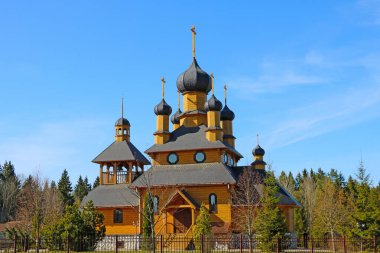Köyde küçük tahta bir kilise ormanın arka planına karşı.