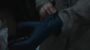 Paltolu kız koyu eldivenler giyer..