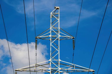 Mavi gökyüzüne karşı yüksek gerilim hattı