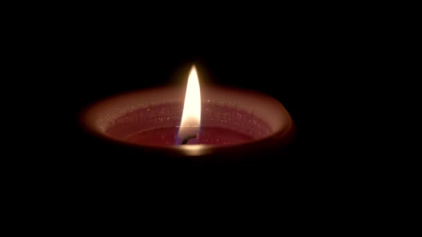 Uma vela está queimando em um fundo escuro. Conceito de tristeza e morte. — Vídeo de Stock
