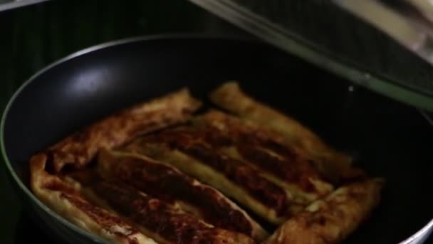 The glass lid of the pan is removed during cooking. Burnt pancakes. — Stock Video