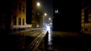 Wroclaw, Polonya, 7 Şubat 2021: Eski şehrin dar yolu boyunca bir tramvay geçiyor. Yağmur ya da yağmur yağıyor.