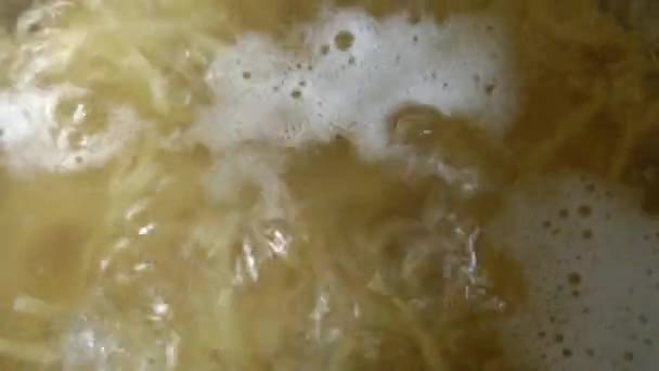 Bovenaanzicht van kokend water en pasta. — Stockvideo