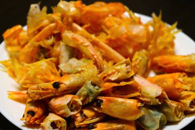 Masada parlak pişmiş karidesli beyaz tabak.