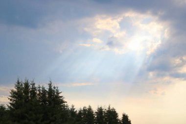 Yağmurdan sonra kara bir bulutun ardından ışık parlar.