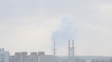 Bulutlu bir kış gününde bacadan duman çıkar. Gezegenin küresel kirliliği.