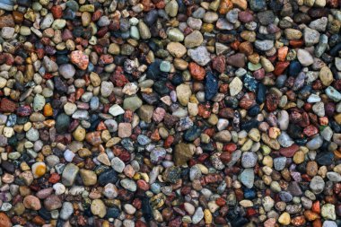 Sahilin üst manzarası renkli taşlar, arka plan.