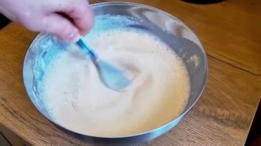 Bir adamın eli krep yapmak ve pişirmek için hamur dövüyordu..