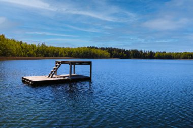 Koyu mavi suyu ve dalış alanı olan güzel bir göl.