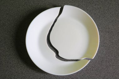 Masadaki kırık beyaz tabağın görüntüsü