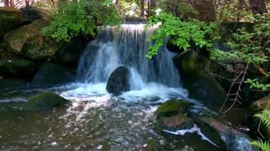 Beautiful small waterfall on a sunny day in the mountains