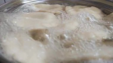 Hamur köftesi yapma sürecine yakın çekim. Kaynar suda kaynatılmışlardır.