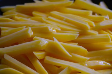 Kızartma tavasında dilimlenmiş patateslerin yakın çekimi.