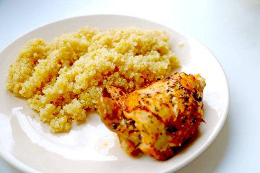 Öğle veya akşam yemeği için fırında tavuk ve yulaf lapası tabağı.