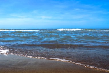 Deniz ya da okyanus kıyısında güzel manzaralı bir sahil. Mavi gökyüzü güneşli açık bir gün