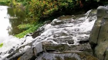 Parktaki yapay bir yamaçta su taşların üzerinden akar.