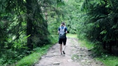 Odaklanamıyorum. Arka plan bulanık. Bir kız dağlık bir alanda ormanda yürüyor, bir gezgin.