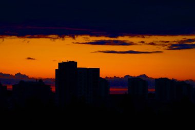 Şehirde resim gibi bir gün batımı siluetleri olan evler..