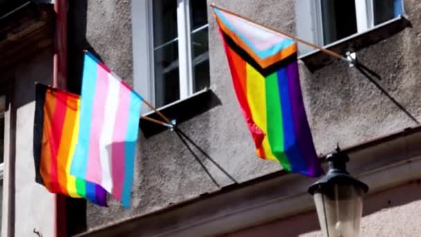 家の建物の上に多色のLbtフラグ 風になびくLgbtゲイの誇りフラグ レズビアン バイセクシャル トランスジェンダー 同性愛者 プライドパレードストリートパーティーのお祝いのための概念 — ストック動画