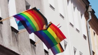 Binadaki Igbt bayrağı yavaşça dalgalanıyor. Renkli LGBT sembolü, odak dışı, film tahılı