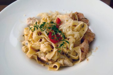 Öğle yemeği için beyaz tabakta etli spagetti.