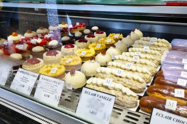 Rouen, Fransa, 30 Temmuz 2025: Fırın vitrininde çeşitli tartlar, eklerler ve pastaların sergilendiği canlı bir Fransız pastası gösterisi. Seçim, çeşitli doku ve tatlara sahip gurme ödüllerini ön plana çıkarıyor, tatlı meraklıları ve aşçılar için mükemmel.