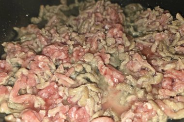 Bir tavada taze sığır eti cızırtısının yakın çekimi, zengin dokusu ve canlı rengi. Aşçılık uygulamaları, tarif geliştirme ya da yemek blogu illüstrasyonları için ideal, pişirme hazırlığının özünü yakalamak.