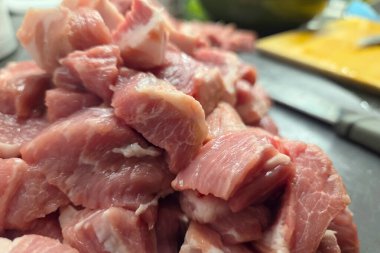 Mutfak tezgahında taze kesilmiş domuz etinin yakın plan görüntüsü, aşçılık hazırlığı için hazır. Sahnede bir yığın pembe, mermer et parçaları, yemek pişirmek için tazelik ve doku veya yemek tarifi kullanımı.