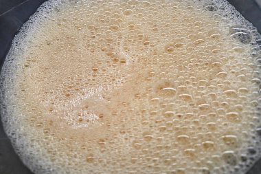 Köpüklü kahve köpüğünün yakından görüntüsü, dokusu ve kabarcıkları. İçecek, aşçılık ve kafe temalı tasarımlar için idealdir. Yeni yapılmış bir kahvenin zengin ve davetkar dokusunu sergiler..