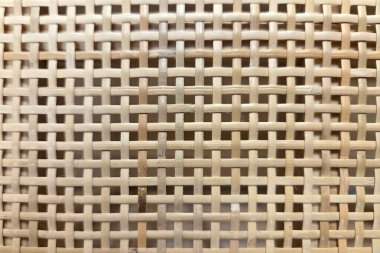 Örülmüş bir rattan deseninin yakından görüntüsü karmaşık detaylar sergiliyor, doğal doku tasarımlarında kullanmak için mükemmel. Ev dekorasyonu, iç tasarım ve çevre dostu temalar için ideal.