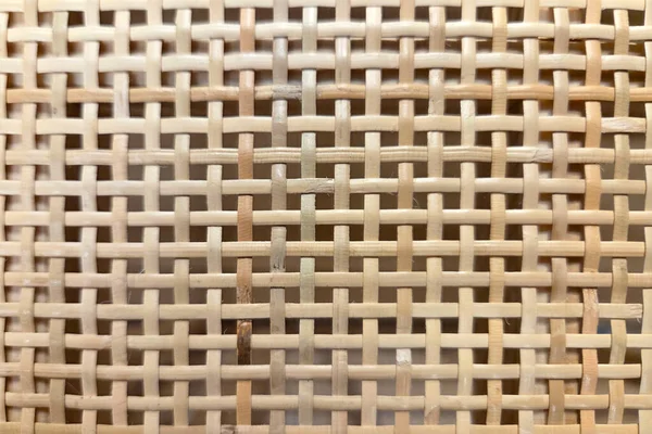 Örülmüş bir rattan deseninin yakından görüntüsü karmaşık detaylar sergiliyor, doğal doku tasarımlarında kullanmak için mükemmel. Ev dekorasyonu, iç tasarım ve çevre dostu temalar için ideal.