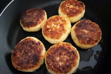 Kızartma tavasında cızırdayan altın rengi peynirli gözlemeler çıtır çıtır, iyi pişmiş dış görünüşlerini sergiliyorlar. Kahvaltı için mükemmel, bu gözlemeler lezzetli ve tatmin edici bir yemek seçeneği sunuyor, altın mükemmelliğinde pişirilmiş..