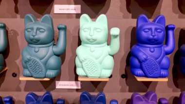 Londra, İngiltere, 13 Aralık 2025: Canlı, mavi ve gök mavisi tonlarında kedi heykelcikleri dokulu bir duvarda sergilenmektedir. Bu dekoratif parçalar geleneksel sembolizmi çağdaş tasarımla harmanlayarak çeşitli iç mekanlara cazibe ve renk katar.