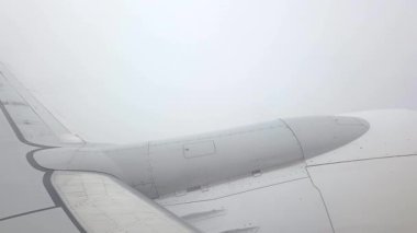 Uçak kanadı yoğun sisle kaplandı. Hava yolculuğunun dinamik doğasını gözler önüne serdi. Modern havacılık teknolojisinin doğal atmosferik koşullarla yan yana gelişini vurgular.