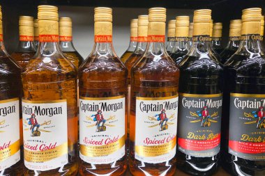 Bologna, İtalya, 4 Ocak 2026: Kaptan Morgan Baharatlı Altın ve Dark Rum şişeleri bir mağazanın rafında dizilmiştir. Sahne etiketleri açıkça gösteriyor. Öğlen oldu ve ışık parlıyor..