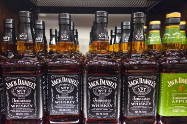 Bologna, İtalya, 4 Ocak 2026: Bir mağazadaki raflarda Jack Daniel 'in viskisinden birkaç şişe sergilenmektedir. Şişeler farklı etiketleri gösteriyor. İnsanlar yakınlarda geziniyor..
