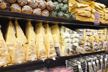 Bolonya, İtalya, 4 Ocak 2026: Bir bakkalda çeşitli İtalyan peynirleri sergilenmekte, parmesanlı reggiano ve vakumlanmış çeşitli peynir kalıpları sergilenmektedir. Aşçılık ve gurme pişirme kavramları için ideal..
