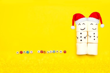 Sarı arka planda kırmızı şapkalı kardan adamlar, klonlanmış mektuplarla mutlu noeller. Mutlu Noel kompozisyonu