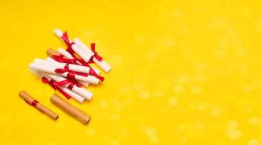 Sarı arka planda kırmızı şeritli küçük kağıt ruloları.