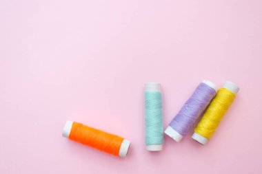 Pembe arkaplanda renkli dikiş ipliği