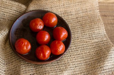 Kır usulü ahşap bir masada vişneli domates turşusu. Konserve kavramı