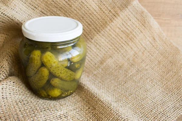 Pickled cucumbers in a glass jar. Pickled cucumbers on the table. Rustic style for Copy space