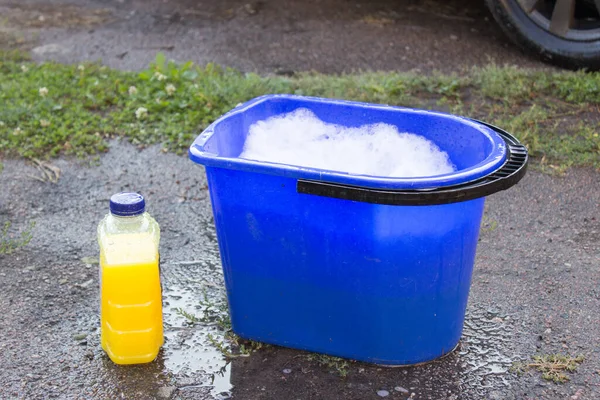 Araba yıkama için şampuan ve kova su, araba temizliği konsepti.