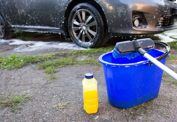 Araba yıkama için şampuan ve kova su, araba temizliği konsepti.